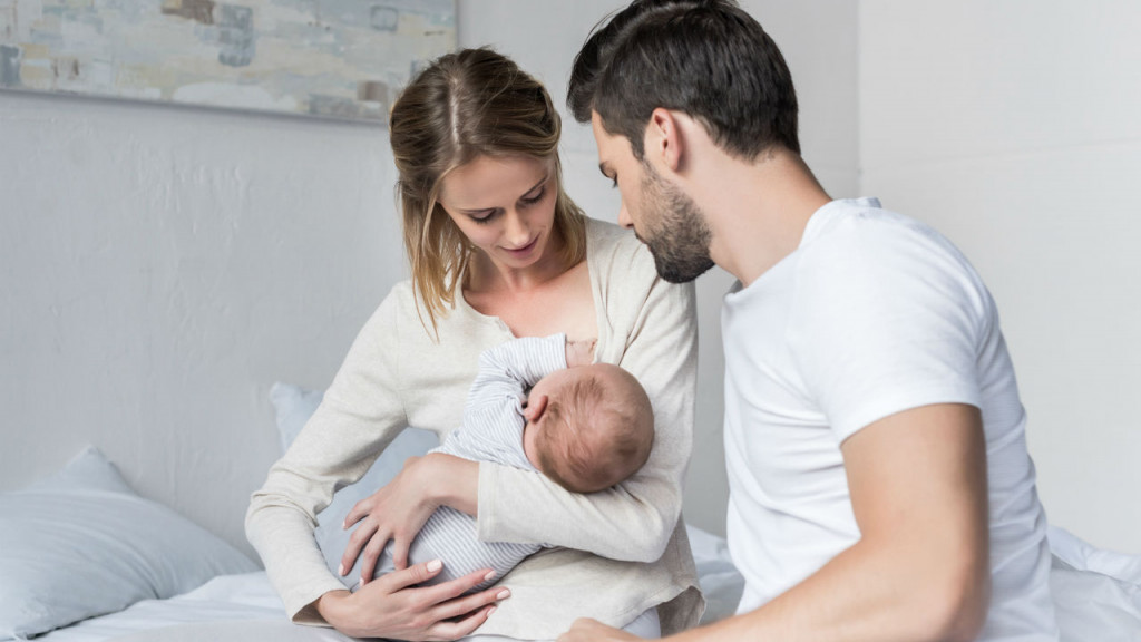 Parents holding their newborn baby during a private location breastfeeding consultation